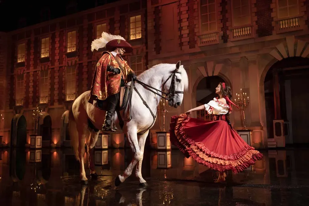 Spectacle des Mousquetaires de Richelieu au Puy du Fou avec des cavaliers et danseuses de flamenco sur une scène d'eau