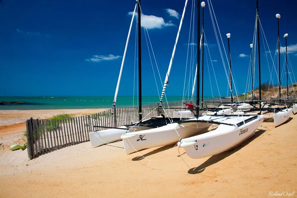 Catamarans de l'école de voile alignés sur le sable fin de la plage à Brétignolles-sur-Mer.
