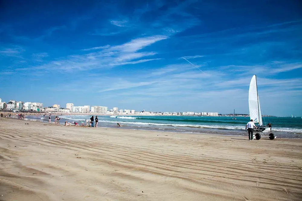 Promenade du Remblai bordée de terrasses et de tentes de plage face à la Grande Plage.