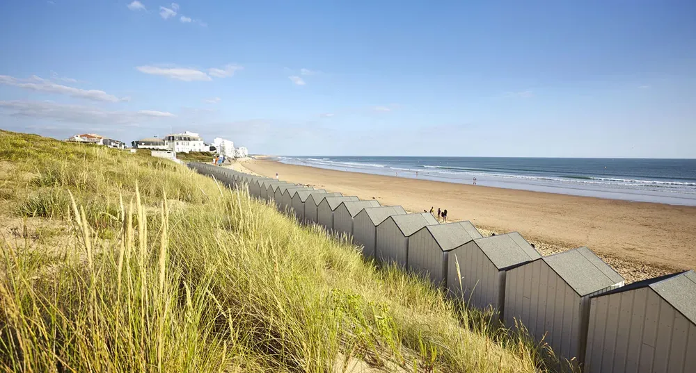 Grande plage de sable fin s'étendant à perte de vue le long du littoral de Vendée